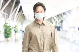尹正穿着卡其色衬衫，搭配黑色长裤，手拿手拎包帅气十足图片