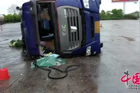 暴雨路滑车速过快 大货车服务区入口失控侧翻图片