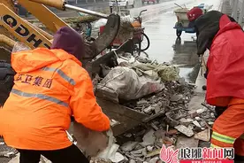 临沂环卫工人雨中清理建筑垃圾 保障市民安全出行图片