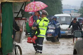 积水挡路 民警淌水送小学生过积水区图片