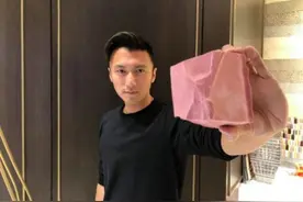 谢霆锋手拿粉色巧克力，面对镜头露喜悦之情图片