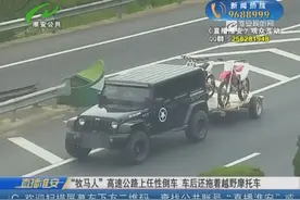 “牧马人”高速公路上任性倒车 车后还拖着越野摩托车图片