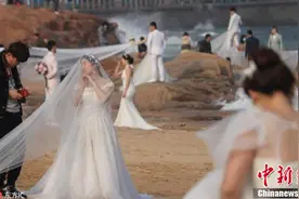 新人扎堆海水浴场拍婚纱照 放眼望去全是白纱图片