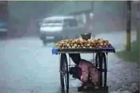 孤零零的父亲竟抱着孩子在板车底下躲避暴雨：其实谁都想早点回家图片