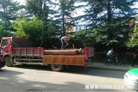 危险！塔吊从马路上往工地内运钢筋图片