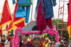 安徽老人单手举起两个孩子 表情轻松图片