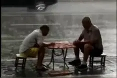 真·棋痴！俩大爷暴雨中下棋不愿离开图片