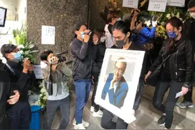 吴孟达儿子抱着遗像送别父亲，陪伴红色棺木走完最后一程图片