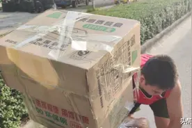 广东女摊主进货途中遇箱子掉落，背上两岁女儿仍在熟睡，过路车主：“我车上有封口胶，等我给你拿来”图片