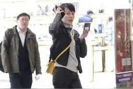 汪涵老婆杨乐乐走机场，皮裤配高跟腿细如筷子，见媒体用手机挡脸图片