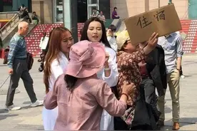 火车站常见举牌大妈：住宿一晚仅需三十？年轻小伙：满满套路图片