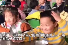 小朋友开饭前拿不锈钢盘子照镜子，被自己帅气的模样迷倒了图片