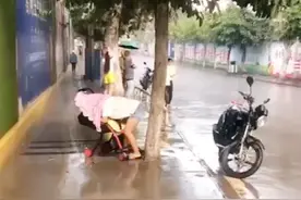 散步时突降大雨，母子俩无处避雨，妈妈之后的举动让行人泪目图片