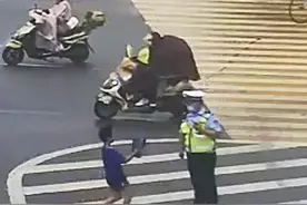 暖心！十堰交警执勤突降大雨 路过男孩跑步送伞图片