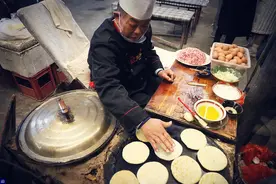大叔在鹅卵石上烙饼，一天卖1000个，赚钱后耗资百万盖小洋楼图片