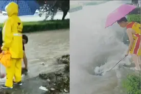 巩义强降雨致道路被积水淹没 父子俩撑伞在暴雨中疏通下水道图片