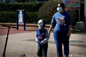 疫情期间男孩戴鬼面具 挤在一起玩跷跷板有些吓人图片