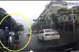 温江辅警冒雨疏导交通全身淋湿 热心市民为他送伞送雨衣图片