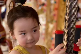 董璇女儿坐旋转木马 穿背心裙绑丸子头超可爱图片
