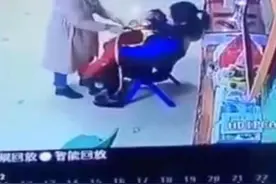 幼儿园老师抱着孩子，另一名老师“负责”扇耳光，爸爸冲进教室图片