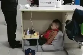 妈妈带娃上班，“最懂事宝宝”不哭不闹，乖巧地待在桌下看动画片图片