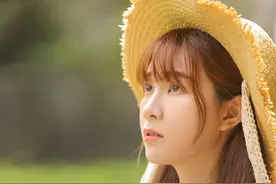 户外草地上的爱笑漂亮美女，戴草帽身穿碎花吊带裙时尚写真图片