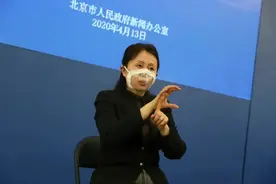 戴透明口罩的人: 北京疫情发布会上的手语翻译图片