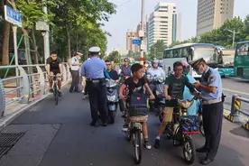济南交警实行“3选1”模式劝导骑电动车佩戴头盔图片