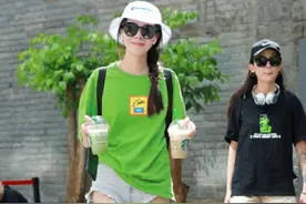 街拍丨清新娇媚的小姐姐穿一件绿色的T恤配牛仔短裤，秀窈窕身材图片