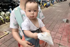 这孩子估计知道快递是他的，竟紧紧抓着不放图片