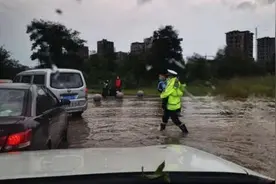 民警抱孩子蹚过积水 他是风雨中最美“摆渡人”图片