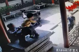 “禁止攀登”标牌前有游客爬到文物上拍照，博物馆工作人员呼吁文明参观图片
