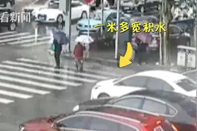 大雨中老人过马路难跨积水 交警上前一个“熊抱”……图片