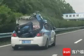 交通拍客 | 太危险！海南高速路上，一出租车后备厢载着电动车疾驰图片