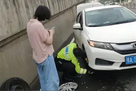 女司机驾车半路爆胎，路过的交警帮她换好图片