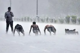 印度新德里迎强降雨 男子雨中做俯卧撑图片