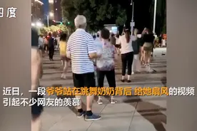 大爷在广场舞老伴的身后为她扇风，这是全广场“最有排面”的大妈图片