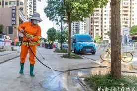 认真对待我的岗，环卫女工将高压水枪系在身上洗路图片