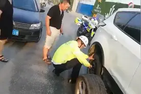 轿车被撞后爆了胎 铁骑队员变身修理工帮忙换胎图片