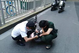 尴尬！女子骑电动车裙角卷入车轮，连人带车摔倒在地图片