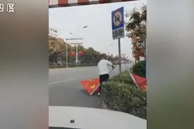 男子开车掉头扶起路边倒地国旗，反复确认后才安心离开，网友点赞图片