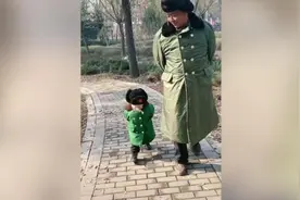 萌娃穿姥爷同款军大衣背手走路 姿势神态惟妙惟肖图片