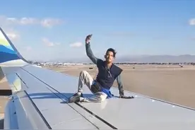 一男子爬上一架即将起飞的客机机翼 四处走动后坠落图片