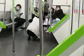 豆浆泼洒地铁车厢后，年轻妈妈两次蹲地擦干净图片