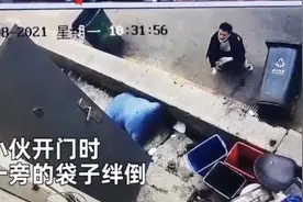 小伙开门瞬间被绊倒，反向“倒栽葱”后单手撑地，蹲在地上自己都笑了图片