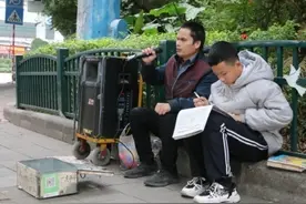 眼里有光！少年街头读书陪盲父卖唱图片
