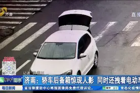 奇葩操作！济南街头一轿车后备厢大敞，人坐上面手里还拽着电动车视频封面