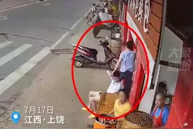 父亲刚将儿子从店前拉回，下一秒飞砸来一块木板图片