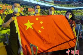 中新社中新网前方报道团在东京奥运会开幕式观众席上展示五星红旗图片
