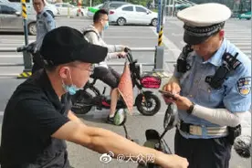 济南交警实行“3选1”模式劝导骑电动车佩戴头盔图片